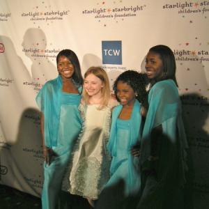 Dakota Fanning and SG3 (Car'ynn, Ca'Shawn & Chris'tol Sims) pose for photographers during Starlight Starbright's 