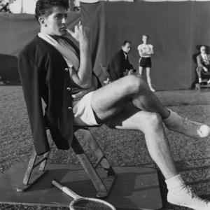 Farley Granger takes a well-earned breather after completing a day's shooting of tennis-playing scenes for 