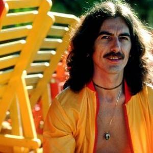 George Harrison in Acapulco posing near wooden lounge chairs January 1977
