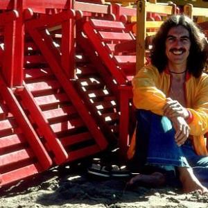 George Harrison in Acapulco posing with coloful wooden lounge chairs January 1977