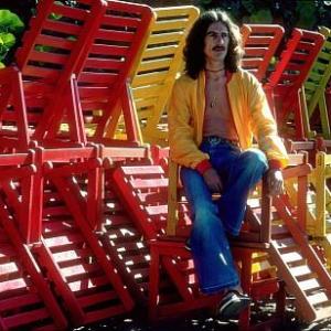 George Harrison in Acapulco posing with colorful wooden lounge chairs January 1977