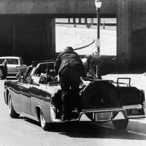 Secret Service Agent Clint Hill leaps aboard presidential limousine to shield JFK and Mrs Kennedy as shots are fired in Dallas on 112263