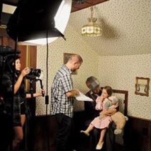 Greg Joseph shooting a scene in FrostE a dark satirical twist on the Christmas standard in which he stars as Pa Malvern shown here holding actress Brooklyn Ray who portrays his granddaughter