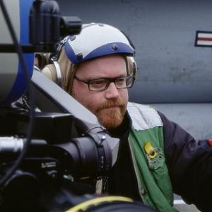 Director JOHN MOORE prepares a shot on location aboard the aircraft carrier U.S.S. Carl Vinson.