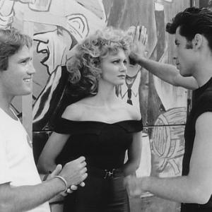 Director Randal Kleiser (left) with Olivia Newton-John (center) and John Travolta (right) on the graduation carnival set.