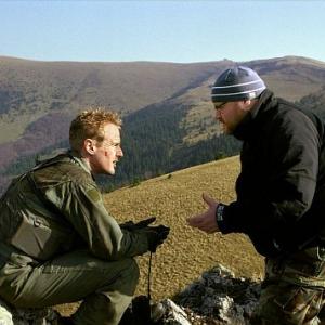 On location in Slovakia, OWEN WILSON (left) confers with director JOHN MOORE on the set of BEHIND ENEMY LINES.