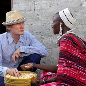 Bill Nighy visits a Maasai community with Oxfam, talking with Elizabeti Lemakanga at a grain depot.