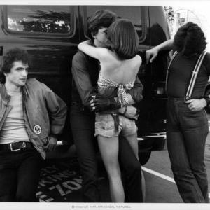 David Wilson (C) embracing Donna Wilkes while Allen G. Norman and John Kirby (R) look on in a scene from the film 'Almost Summer', 1978. (Photo by Universal Pictures/Getty Images)