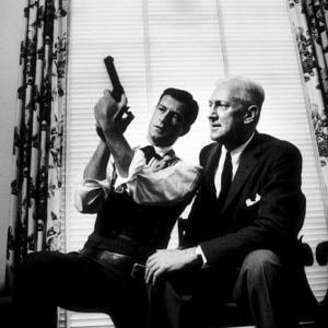 Hugh O'Brien and Pete Martin looking at a prop gun from O'Brien's TV show, 