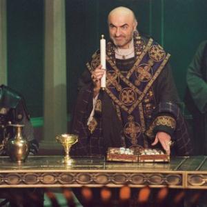 Arthur (Clive Owen, left) listens as Bishop Germanius (Ivano Marescotti, center) requests a final challenge of Arthur's Knights of the Round Table while Horton (Pat Kinevane, right) looks on.
