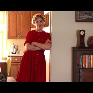 Marilyn Greenglass (Laura Poe) the quintessential 1950s house wife standing in the doorway watching the hard working Dr. Greenglass go back to work on a weekend - 