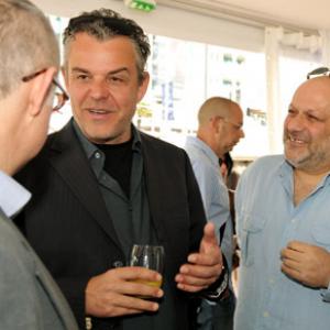 Director Eran Riklis (R) and actor Danny Huston (C) talk to guests as they attend the Danny Huston Press Breakfast held at the Moet Salon, Baoli Beach during the 63rd Annual International Cannes Film Festival on May 14, 2010 in Cannes, France.