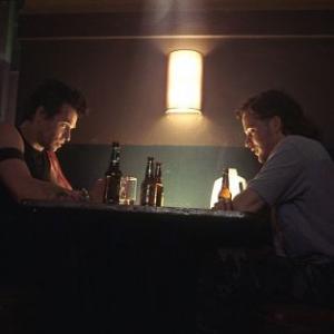 Danny (Val Kilmer) and Jimmy the Fin (Peter Sarsgaard) meet at a bar to discuss Danny's plan.