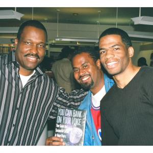 Rodney takes a photo with a couple of attendees at the 2004 book signing of his best seller You Can Bank on Your Voice