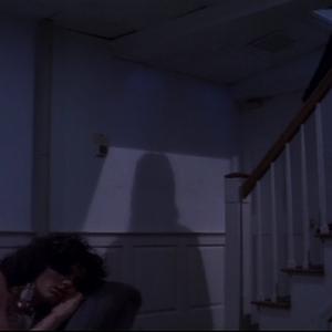 Lolita Christy Scott Cashman sleeps on a recliner oblivious to the looming shadow cast by Judd Eric Scheiner as he descends the stairs in a scene from filmmaker Angel Connells BENEATH THE VENEER OF A MURDER 2010