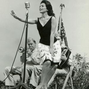 Lisa Seagram singing in the forground in a scene from ABCs McHales Navy Starring Enrnest Borgnine