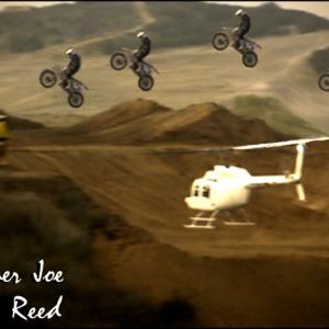 Helicopter flying while motorcycle jumps over