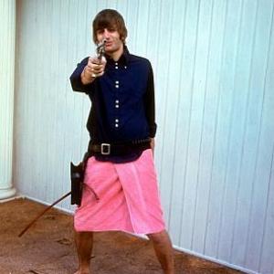 The Beatles Ringo Starr wearing a towel on his waist and playing with his gun 1964