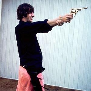 The Beatles Ringo Starr grips his right wrist to steady his gun positioning