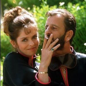 Ringo Starr smokes a cigaretee while wife give him a hug