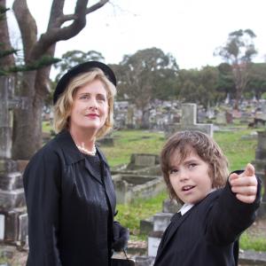 Miss Judy (Sonia Todd) and Joshua (Karl Beattie) at the funeral.