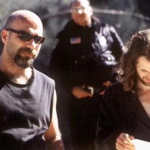Set still photograph of Kevin Gage and Stephen Wozniak between takes on location in the Angeles National Forest for the true crime feature film CHAOS