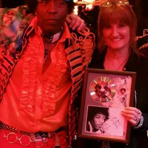 Lenny Holmesas Jimi Hendrix with Hendrix Forever Band Vicki Johnson Senior Publicist presented Holmes with Signed Autograph display of Jimi Hendrix on Stage
