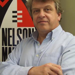 Tony Hollingsworth in front of a poster for the first Nelson Mandela concert in 1988