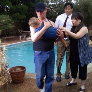 Thom Michael Mulligan (Pete Young)Carries young son from swimming pool in a movie still from the Multi Award Winning Feature film Callous