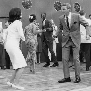 Steve McQueen dancing with Lucy Johnson at a Democratic fundraiser as photographer William Claxton photographs the scene from the other side of the dance floor circa 1966