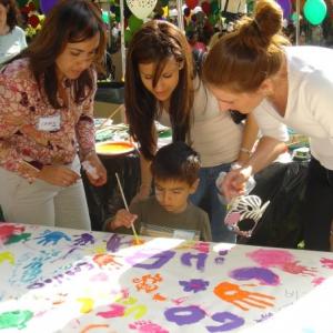 Deidra Sarego at The Art of Elysium NICU event teaching children how to paint
