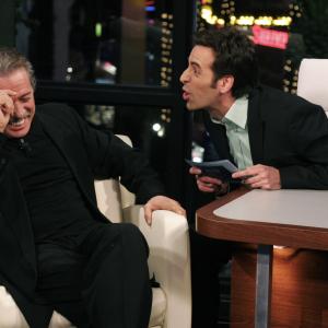 Talk show host Alex Cambert making actor Edward James Olmos laugh so hard his face is red during an interview on Mas Vale Tarde con Alex Cambert