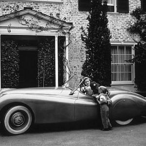 Humphrey Bogart, Lauren Bacall and son Stephen at home in Beverly Hills with his XK 120 Jaguar