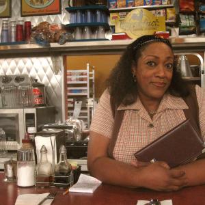 Rules of Engagement's Doreen behind the Island Diner counter