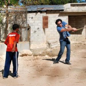 Joe Floccari taking a break from shooting a documentary in the Dominican Rebublic... Playing some stick ball in a Barrio.
