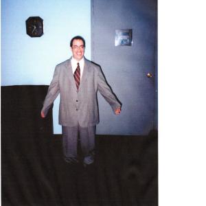 Jeff Eigen as a short guy in a big suit on the set of an ATT commercial
