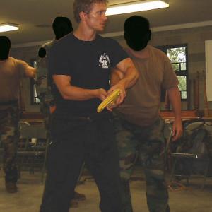 Jared Day instructing United States Special Operations soldiers in a gun disarming technique.