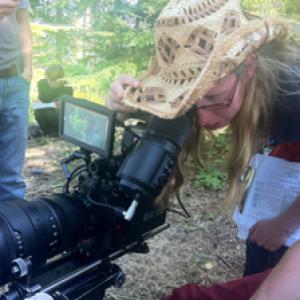 Holly Chadwick as Director checking the frame on the forested set of Seeking Solace