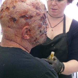 Midian Crosby applying a silicone zombie makeup at Event for Free Comic Book Day 2012 at I Want More Comics Thornton CO