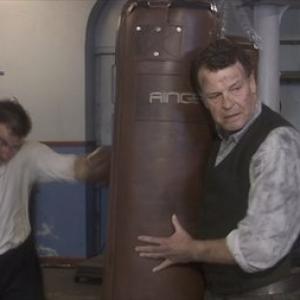 John Noble portrays world famous boxing manager and trainer Eddie Thomas, holding the bag for his prodigy Howard Winstone (Stuart Brennan).