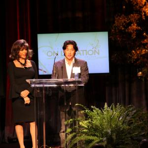 Joan Collins presents Kent Matsuoka the 2010 COLA award for Commercial Location Professional of the Year