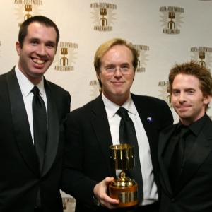 Presenters Matthew Senreich and Seth Green flank Brad Bird, winner for best feature writing