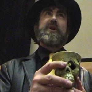 Davro the Criminal Mastermind Played by Scott Johnson holding a scull cup.