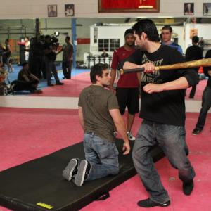 Jin coordinates an action sequence with stunt men.