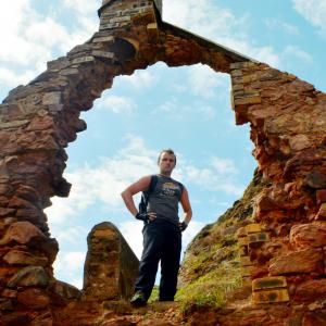 Shawn stands in the arch of the dilapidated smugglers bothy