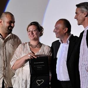 Filmmaker producer and festival director Diana El Jeiroudi receives with her partner Orwa Nyrabia the Katrin Cartlidge Award at Sarajevo Film Festival 2012 presented by Festival director and Jeremy Irons