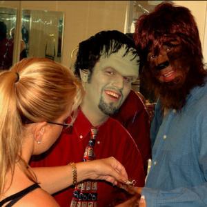 Makeup artist Angela Bazelman works on the hairy hands of Dean Ronalds as Max Bullis looks on.