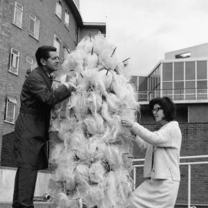 5th August 1965: Daphne Dare, who designs all the Dr Who costumes, with her latest creation, a Varga. Assisting is John Athins of the BBC wardrobe Dept.