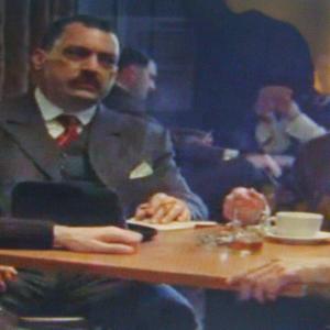 HBO Boardwalk Empire Gangster Ken Sladyk in a Chicago meeting with Johnny Torrio Waiting with pencil and paper in hand Johnny Torrio shows his high powered money controller the envelope thick with cash that Jake Guzik brings in scene 110