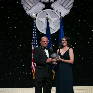 NATL HARBOR MD  SEPT 16 2015 Director Kim Furst receives Mr Robert A Bob Hoovers Lifetime Achievement Award on his behalf during the 2015 Annual Air Force Associations Anniversary Awards Gala
